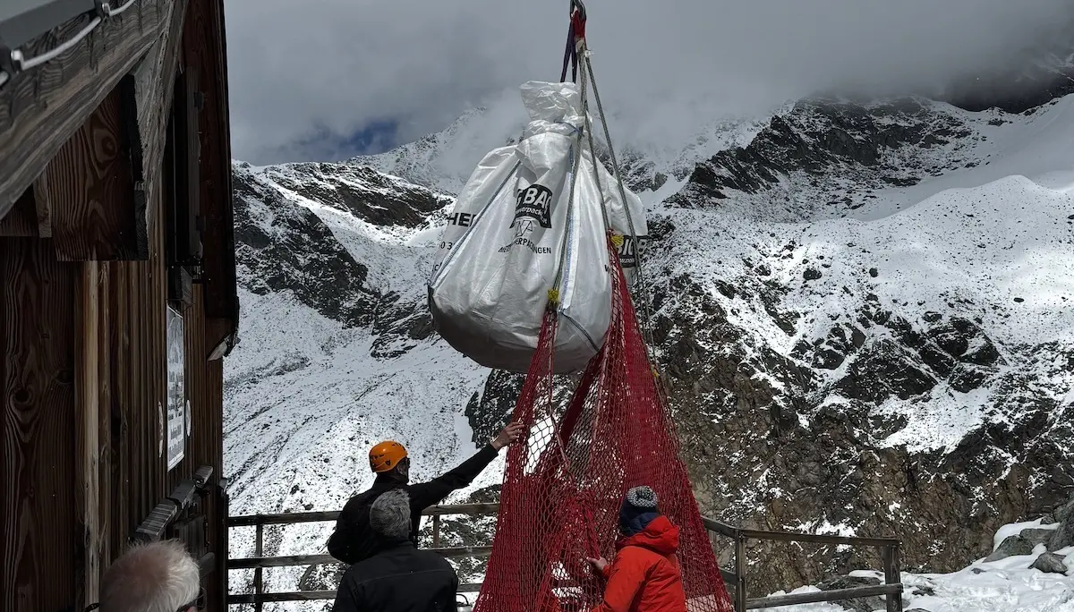 Ein Helikopter Pilot lädt Holz direkt vor der Tür der Rauhekopfhütte ab. | © Helmut Schgeiner